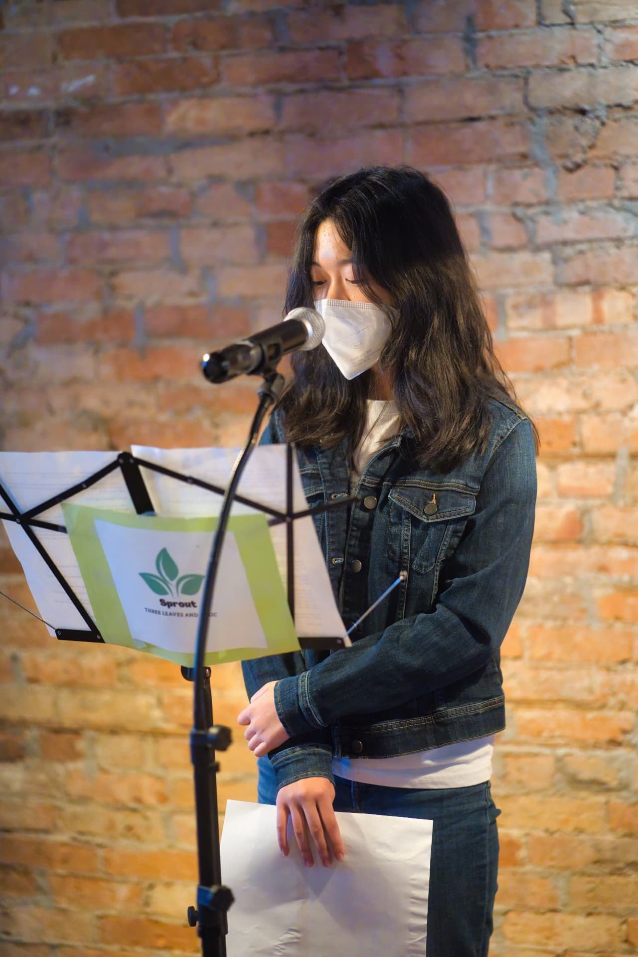 A young storyteller reading at a Sprout open mic in June 2022