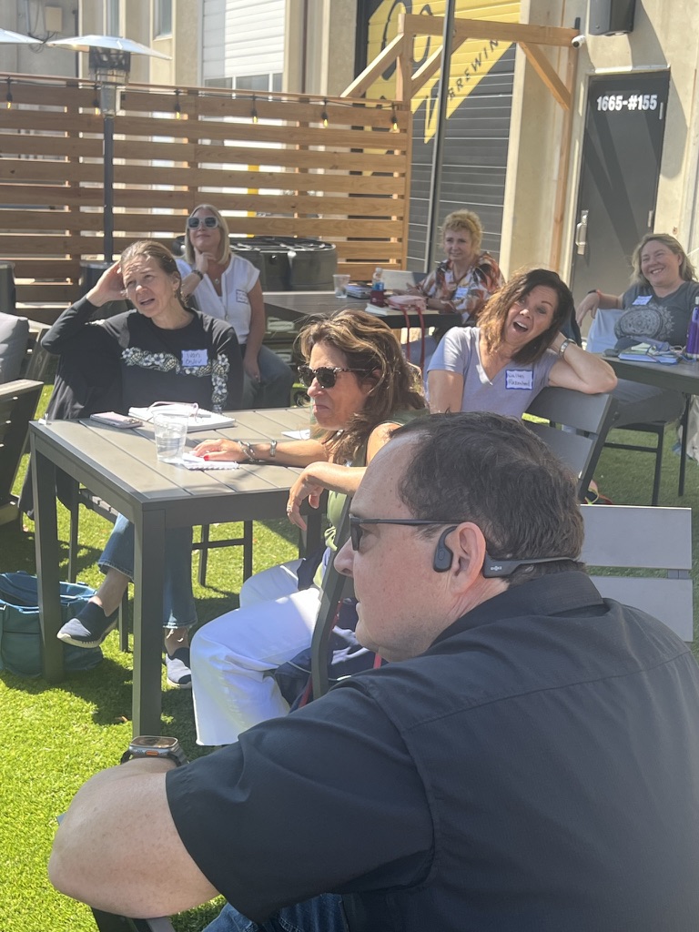 Workshop participants listening outdoors on a sunny afternoon